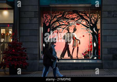 Shopper gehen vorbei an Harvey Nichols Kaufhaus Christmas Window, St Andrew Square, Edinburgh, Schottland, Großbritannien Stockfoto