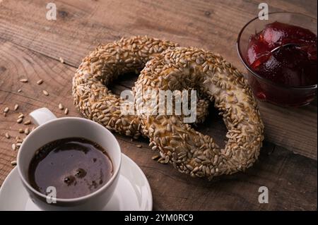Frisch gebackenes Gebäck zum Frühstück, bayerisch gekochte Teigbrezeln, Kaffee und hausgemachte Marmelade Stockfoto