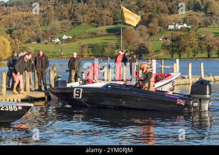 Eine Gruppe von Personen beobachtet den Fahrer eines schwarzen Motorbootes, der an einem Steg oder Dock auf Coniston Water bei der Coniston Power Boat Records Week 2021 ankert Stockfoto