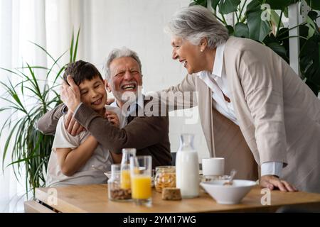 Glückliche Familie mit gemischter Rasse. Lächelnde Großeltern, die Spaß mit dem kleinen Enkelkind zu Hause haben. Stockfoto