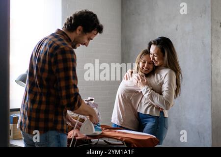 Glückliche Familie gemischter Rasse, die gemeinsam Hausarbeiten macht, bügelt, Haushalt zu Hause zusammen. Stockfoto