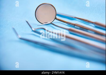 Zahnärztliche Werkzeuge auf blauem Hintergrund, die Instrumente für Mundhygiene und Untersuchung hervorheben Stockfoto