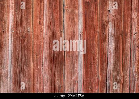 Alte verwitterte Bretter ab einer Wand, texturiertes Holz, rote Farbe, Hintergrund mit vertikalen Linien Alte verwitterte Bretter ab einer Wand, textu Stockfoto