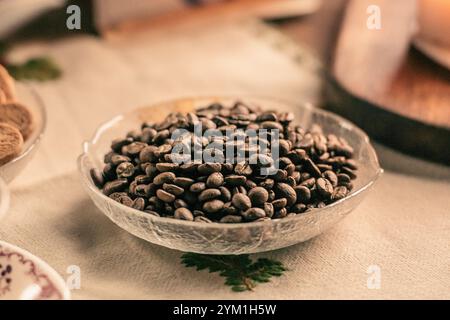 Kaffeebohnen oder Samen in einer Glas- oder Kristallschale auf einem Tisch, Vintage Hintergrund Stockfoto