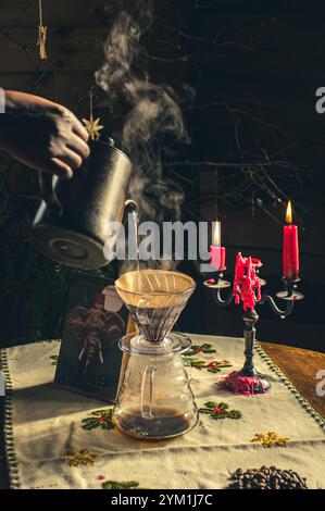 Gießen Sie Filterkaffee über eine alternative Brühmethode. Mädchen gießt heißes Wasser über geröstete und gemahlene Kaffeebohnen, die im Papierfilter enthalten sind. Keramik Stockfoto