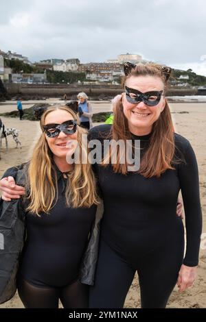Die Teilnehmer treffen sich am Strand von Towan und bereiten sich auf die jährliche Veranstaltung „Superhero in the Cold“ vor, um Spenden für die britische Krebsforschung zu sammeln. Stockfoto