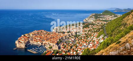 Panorama von Dubrovnik, Kroatien: Historische Altstadt mit Festungsmauern, orangefarbenen Dächern und einem Jachthafen an der Adria. Umgeben von Hügeln und üppig Stockfoto