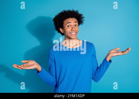 Foto-Porträt des gutaussehenden jungen Mannes zuckende Schultern gekleidet stilvolles Kleid isoliert auf blauem Hintergrund Stockfoto