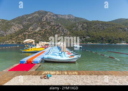 Blick auf den Strand der Blauen Lagune mit vertäuten Freizeitbooten und Katamaranen, die an einem sonnigen Sommertag vermietet werden können, Oludeniz, Türkei Stockfoto