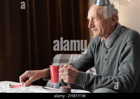 Einsam vergessen von Kindern alter Mann, der allein zu Hause Geburtstag feiert Stockfoto