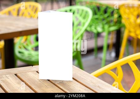 Leere Broschüre auf dem Tisch in Restaurants Sommerterrasse in der Stadt. Broschüre mit Kopierraum. Mock-Up Stockfoto