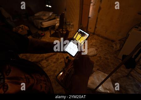 Alfafar, Spanien - 19. November 2024. Vicente, wohnhaft in Alfafar an der Torrente Avenue vor dem parque Alcosa, ließ sein Haus vollständig vom Wasserstrom untertauchen. Er zeigt die Höhe, die durch die Flut erreicht wurde, und zwei Fotos, die von derselben Stelle aufgenommen wurden, zum Fenster und zu den Straßenverhältnissen. In weniger als 15 Minuten stieg das Wasser um mehr als 1 Meter und das Motorrad (auf dem Foto) wurde weggefegt. Zu diesem Zeitpunkt hatten die Behörden noch nicht den roten Alarm gemeldet. Quelle: Roberto Arosio/Alamy Live News Stockfoto