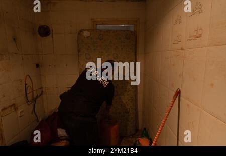 Alfafar, Spanien - 19. November 2024. Vicente, wohnhaft in Alfafar an der Torrente Avenue vor dem parque Alcosa, ließ sein Haus vollständig vom Wasserstrom untertauchen. Er zeigt die Höhe, die durch die Flut erreicht wurde, und zwei Fotos, die von derselben Stelle aufgenommen wurden, zum Fenster und zu den Straßenverhältnissen. In weniger als 15 Minuten stieg das Wasser um mehr als 1 Meter und das Motorrad (auf dem Foto) wurde weggefegt. Zu diesem Zeitpunkt hatten die Behörden noch nicht den roten Alarm gemeldet. Quelle: Roberto Arosio/Alamy Live News Stockfoto