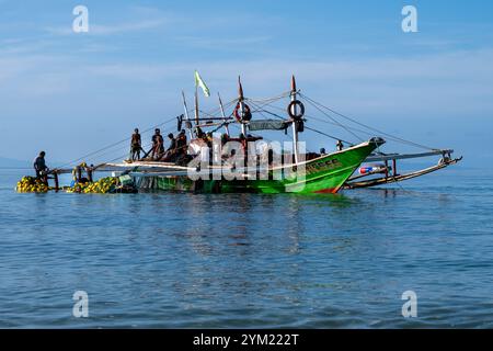 Laiya Beach, Batangas, Philippinen - 16. August 2024: Fischer, die mit dem frühen Morgencach an Land kommen. Die Menschen in den Dörfern der Küstenprovinz leben weiterhin auf traditionelle Weise Stockfoto