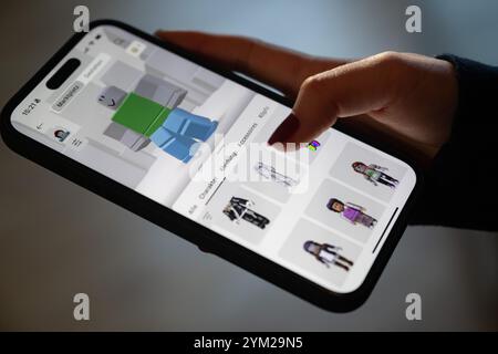 Stuttgart, Deutschland. November 2024. Ein Mädchen betreibt ein Smartphone, auf dem die Roblox-App zu sehen ist (posierte Szene). Quelle: Marijan Murat/dpa/Alamy Live News Stockfoto