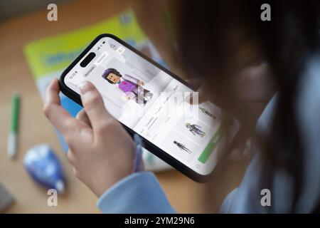 Stuttgart, Deutschland. November 2024. Ein Mädchen betreibt ein Smartphone, auf dem die Roblox-App zu sehen ist (posierte Szene). Quelle: Marijan Murat/dpa/Alamy Live News Stockfoto