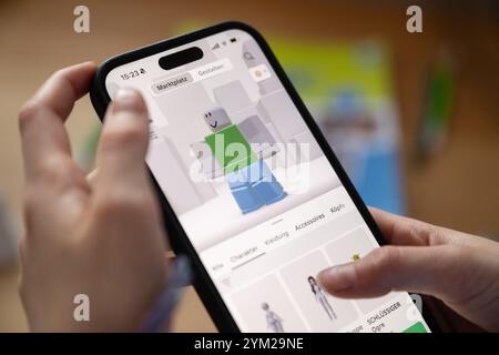 Stuttgart, Deutschland. November 2024. Ein Mädchen betreibt ein Smartphone, auf dem die Roblox-App zu sehen ist (posierte Szene). Quelle: Marijan Murat/dpa/Alamy Live News Stockfoto