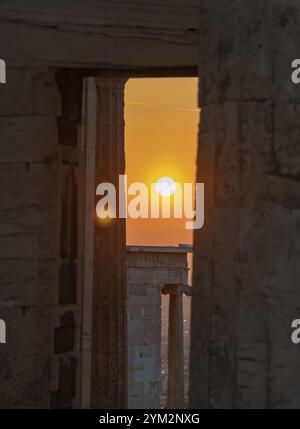 Ein Bild des Sonnenuntergangs, gesehen durch die Ruinen von Propyläen, dem Tor zur Akropolis von Athen Stockfoto