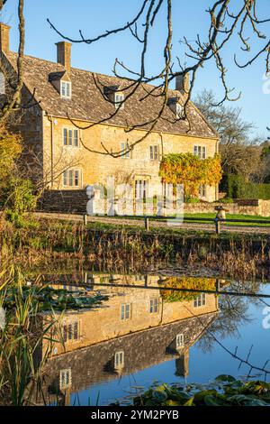 Abendlicht auf der College Farm neben dem Teich auf dem Grün im Dorf Cotswold in Wyck Rissington, Gloucestershire, England Großbritannien Stockfoto