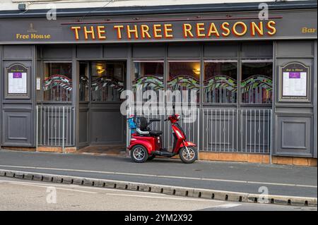 Mobility Scooter parkte auf einem Bürgersteig neben dem Three Reasons Pub, Gallowgate Street, Largs, North Ayrshire, Schottland, Großbritannien, Europa Stockfoto