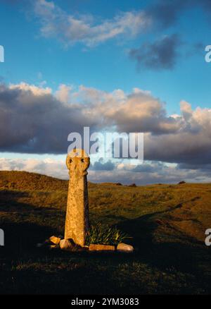 Blick auf W des St Piran's Cross in Penhale Dunes, Perranporth, Cornwall, England, Großbritannien: Ein frühmittelalterliches Granitsäulenkreuz mit Radkopf und drei Löchern. Stockfoto