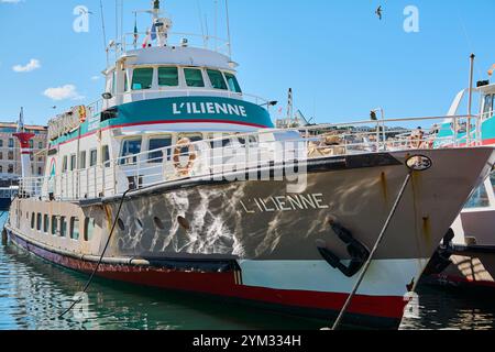 Marseille. Frankreich - 20. November 2024: Die Fähre L'Ilienne liegt am malerischen Alten Hafen von Marseille, mit klarem blauem Himmel und Reflexen o Stockfoto