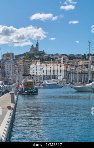 Marseille. Frankreich - 20. November 2024: Der malerische alte Hafen von Marseille mit Reihen von Segelbooten und Yachten, historischen Gebäuden und der Notre-Dame Stockfoto