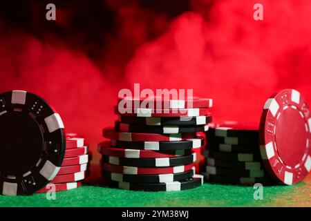 Pokerspiel. Casino Chips auf grünem Tisch in Neonlichtern, Nahaufnahme Stockfoto