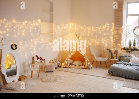 Gemütliches Kinderzimmer mit Zelt, Geschenken und dekoriertem Weihnachtsbaum Stockfoto