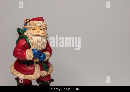 Weihnachtsmann-Figur mit einer Geschenktüte auf hellem Hintergrund. Shaker HEarth weihnachtliche Einrichtung. Stockfoto