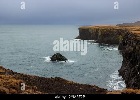 Klippen an der Atlantikküste. Herbstlicher bewölkter Regenhimmel. Arnarstapi, Halbinsel Snaefellsnes, Island. Stockfoto