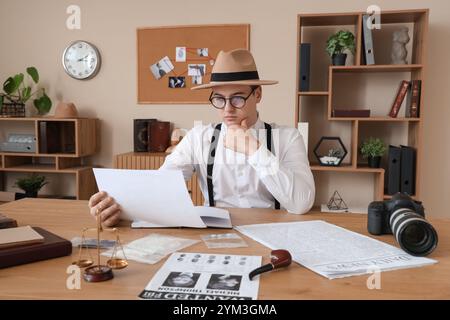 Männlicher Detective untersucht den Fall am Tisch im Büro Stockfoto