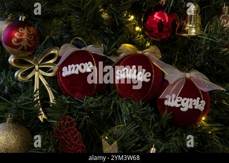 Drei rote Kugeln mit weißen Bögen und den Worten „Amor, Salade, Alegria“ darauf Stockfoto