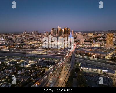 Luftaufnahme der Innenstadt von Los Angeles bei Nacht, die beleuchtete Wolkenkratzer, dichten Autobahnverkehrsstau und urbane Ausbreitung zeigt Stockfoto