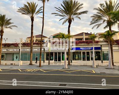 Geschäfte der Centro Commercial Safari auf der von Palmen gesäumten Playa de las Américas. Arona, Teneriffa, Kanarische Inseln, Spanien. Februar 2023. Stockfoto