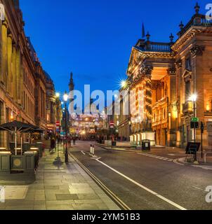 Blick in die Abenddämmerung zur Weihnachtszeit auf der Grey Street in Newcastle upon Tyne in Richtung Theatre Royal und Grey's Monument mit Weihnachtsbeleuchtung Stockfoto