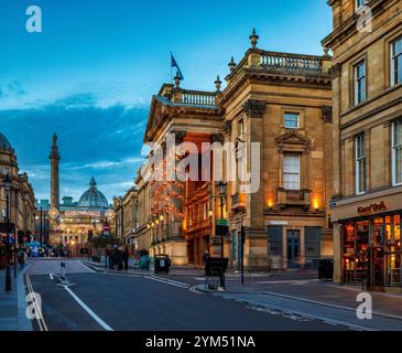 Blick in die Abenddämmerung zur Weihnachtszeit auf der Grey Street in Newcastle upon Tyne in Richtung Theatre Royal und Grey's Monument mit Weihnachtsbeleuchtung Stockfoto