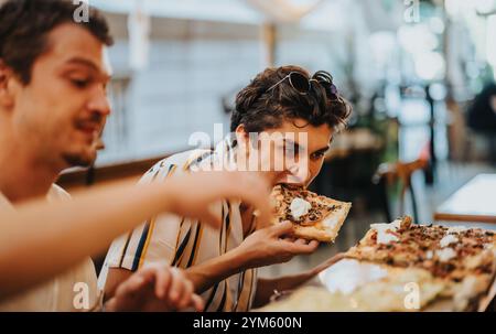 Freunde genießen gemeinsam Pizza in einem gemütlichen Restaurant Stockfoto