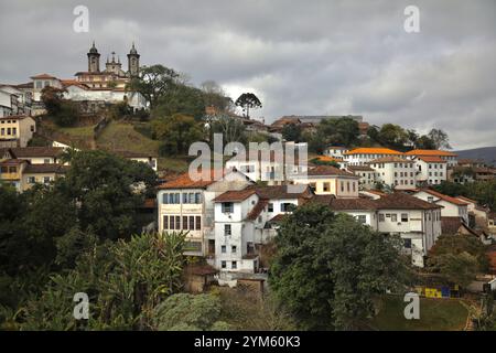 Die Stadt Ouro Preto, die über mehrere Hügel verteilt ist, ist abgebildet. Ouro Preto ist eine brasilianische Kolonialstadt in der Provinz Minas Gerais, die 1711 nach der Entdeckung von Gold in der Region gegründet wurde. Die Stadt wurde durch diese Bergbautätigkeit allmählich reicher. Die Kolonialarchitektur und die barocken Kirchen, von denen einige vom berühmten Maler und Bildhauer Aleijadinho verziert wurden, sind erhalten geblieben. Stockfoto