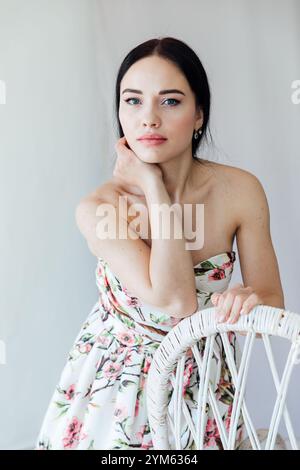 Schöne Frau im Sommerkleid mit Blumen auf weißem Hintergrund Stockfoto