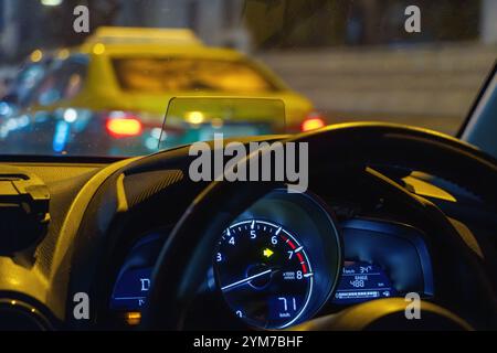 Blick auf den Nachtverkehr in der Stadt durch die Windschutzscheibe eines fahrenden Autos Stockfoto