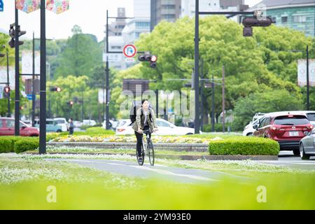 Eine junge Frau, die Pakete mit dem Fahrrad liefert Stockfoto