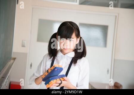 Grundschulmädchen hält Tafelradierer Stockfoto