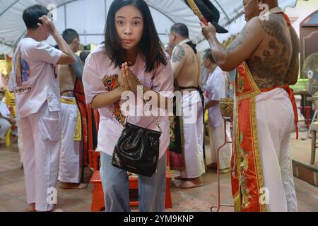 Am Ende des vegetarischen Festivals in einem chinesischen Tempel in Phuket, Thailand, unterzieht eine junge thailändische Frau einem Ritual namens Crossing the Bridge Stockfoto