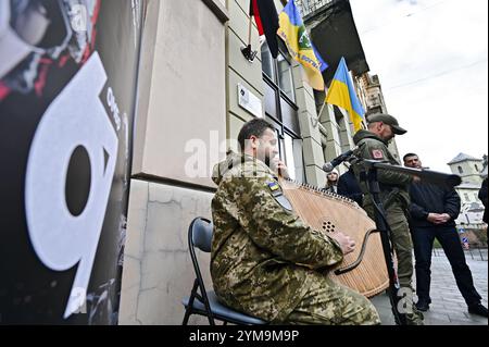 Nicht exklusiv: LEMBERG, UKRAINE - 15. NOVEMBER 2024 - Ein Mann in Militäruniform spielt die Bandura während der Eröffnung des Ukraines First Recruitment cen Stockfoto
