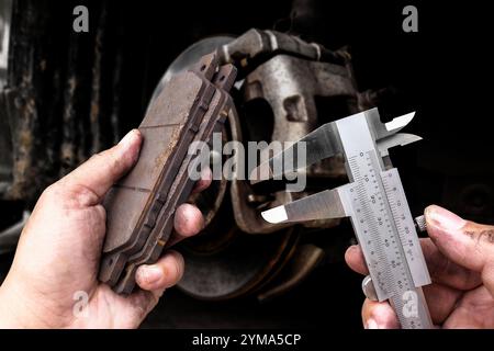 Präzisionsmessung von Bremsbelägen mit Messschieber durch Automechaniker , Kfz-Wartungskonzept Stockfoto