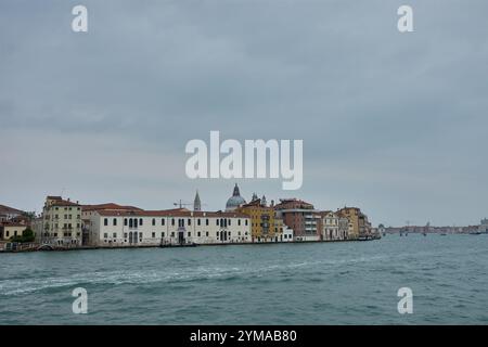 Venedig, Italien; Oktober, 17.2024: Typisch venezianische Architektur mit lebhaften Fassaden und Terrakottadächern, die sich im stillen Wasser eines Kanals spiegeln. Stockfoto