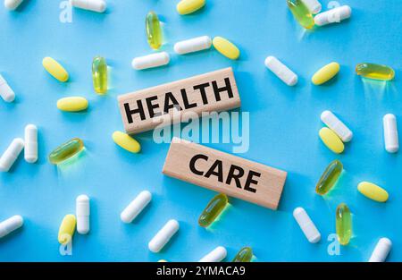 Gesundheitssymbol. Holzblöcke mit Worten Healthcare. Schöner blauer Hintergrund mit Pillen. Medizin und Gesundheitskonzept. Kopierbereich. Stockfoto