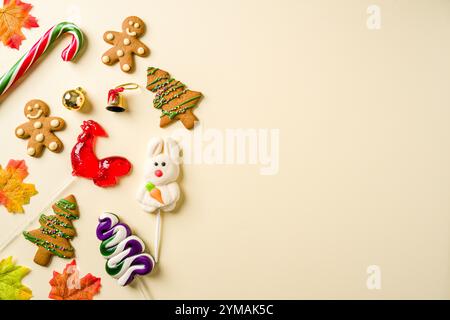 Weihnachtshintergrund mit Hahnenbonbons, Lebkuchenkeks und verschiedenen Weihnachtsdekorationen auf gelbem Hintergrund Stockfoto