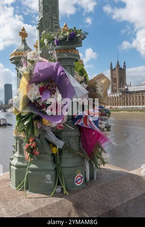 April. Zehn Tage nach dem Terroranschlag in Westminster halten die Menschen immer noch an, um die Blumen für die Opfer rund um die Lampenstandards auf der Waterloo Bridge zu sehen und zu fotografieren. Stockfoto